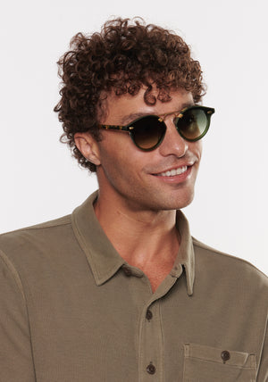 STL NYLON | Bottle Green + Zulu 18K Handcrafted, luxury dark green acetate round KREWE sunglasses with flat edge to edge nylon lens and 18k gold metal bridge mens model | Model: Miguel