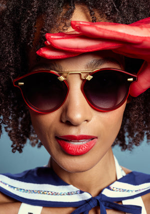 STL NYLON | Cherry 18K Handcrafted, luxury red cherry acetate round KREWE sunglasses with flat edge to edge nylon lens and 18k gold metal bridge womens model campaign | Model: Melie